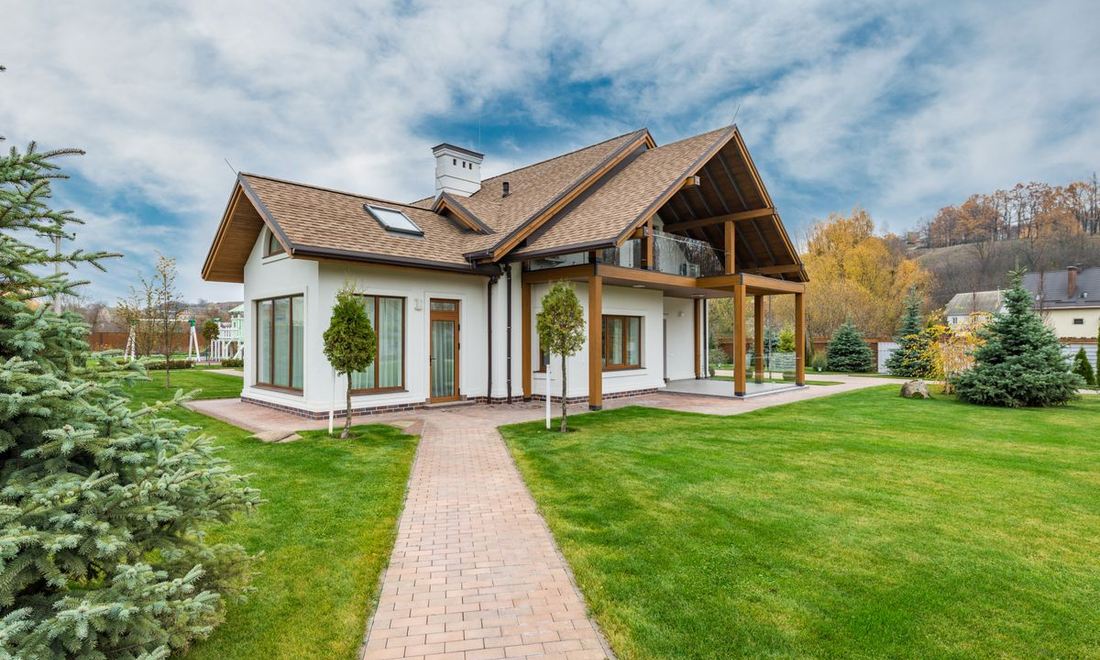 A suburban home with a porch and paver walkway